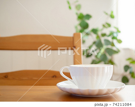 テーブルに置かれたラテの入ったカップ 74211084