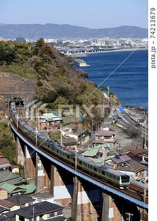 小田原市街地をバックに走るE233系電車 74213679
