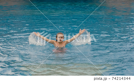 The little cute girl have fun in the pool. The child enjoy summer vacation in a swimming pool jumping, spinning, splash water. Happy childhood. The little cute girl have fun in the pool. The child enjoy summer vacation in a swimming pool jumping, spinning, splash water. Happy childhood. 74214344