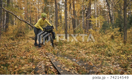 The woman travel on mixed terrain cycle touring with bikepacking. The traveler journey with bicycle bags. Sport tourism bikepacking. The woman travel on mixed terrain cycle touring with bikepacking. The traveler journey with bicycle bags. Sport tourism bikepacking. 74214549