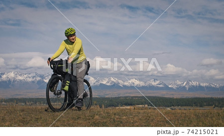 The man travel on mixed terrain cycle touring with bikepacking. The traveler journey with bicycle bags. Sport tourism bikepacking. 74215021