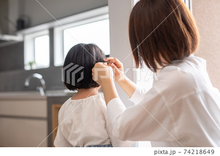 家の中で母親が娘の髪の毛をセットしている　mother hair child 74218649