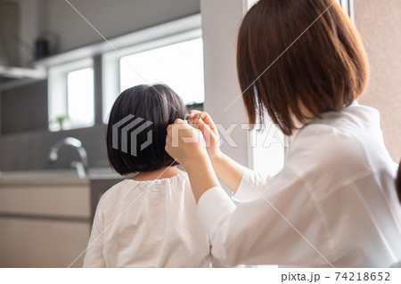 家の中で母親が娘の髪の毛をセットしている　mother hair child 74218652