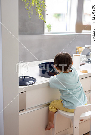 白いキッチンで男の子が青い鍋で料理をしている　boy kitchen  74220300