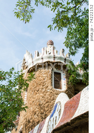 スペインバルセロナのグエル公園の石垣とタイル張りの飾りと円筒形の石造りの建物の写真素材