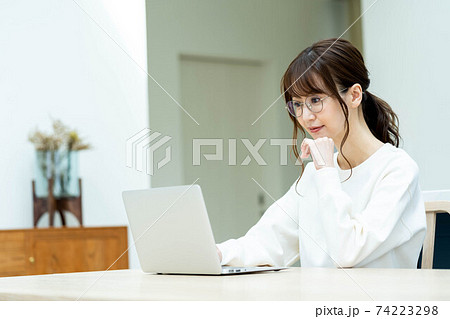 リビングのテーブルでノートパソコンを使う女性 リビングのテーブルでノートパソコンを使う女性 74223298