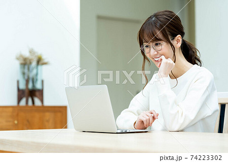 リビングのテーブルでノートパソコンを使う女性 74223302