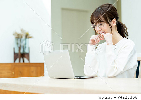 リビングのテーブルでノートパソコンを使う女性 リビングのテーブルでノートパソコンを使う女性 74223308