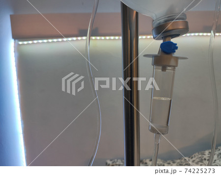 Hospital dropper with saline solution. White background with a led strip. Horizontal photography. Hospital dropper with saline solution. White background with a led strip. Horizontal photography. 74225273