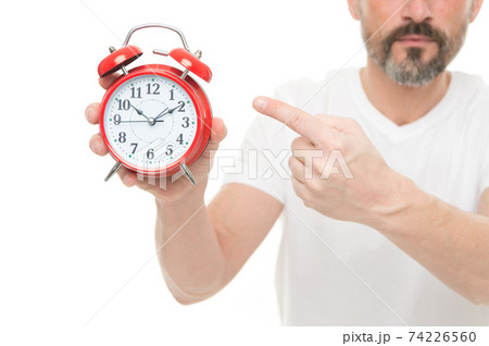 Check time. Man hold alarm clock in hand. Guy bearded  74226560