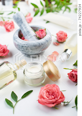 Handmade rose cosmetics concept of mortar and pestle with rose buds with dropper and bottles with serum and oil on white background Handmade rose cosmetics concept of mortar and pestle with rose buds with dropper and bottles with serum and oil on white background 74227934