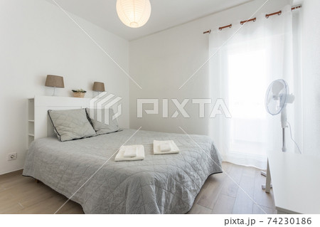 Minimalistic bedroom in bright colors and white walls. European style. Minimalistic bedroom in bright colors and white walls. European style. 74230186