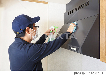 ガスレンジの換気扇の掃除をするハウスクリーニングの男性作業員 ガスレンジの換気扇の掃除をするハウスクリーニングの男性作業員 74231451