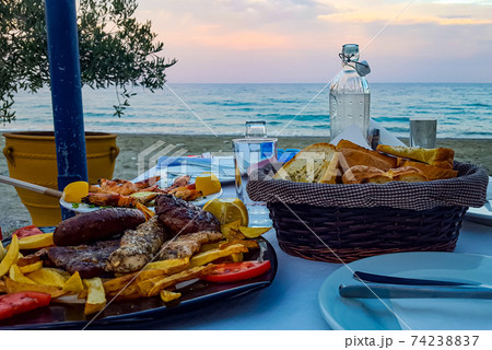 Lovely dinner on the shores of the Aegean Sea at sunset  74238837