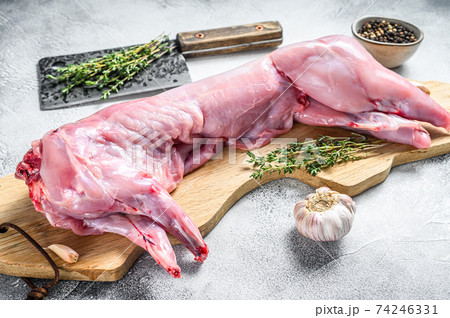 Raw hare meat on a cutting board. White background. Top view Raw hare meat on a cutting board. White background. Top view 74246331