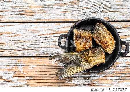 Roasted piece of silver carp. Wooden background. Top view. Copy space Roasted piece of silver carp. Wooden background. Top view. Copy space 74247077