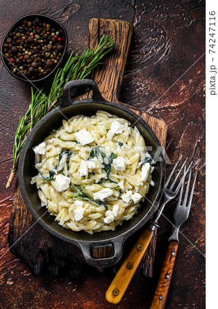 Orzo primavera with green veggies spinach. Dark wooden background. Top view 74247116