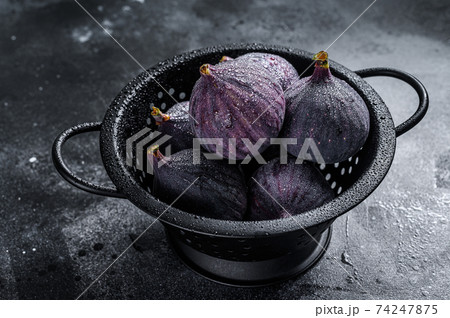 Ripe purple Figs in colander. Black background. Top view 74247875