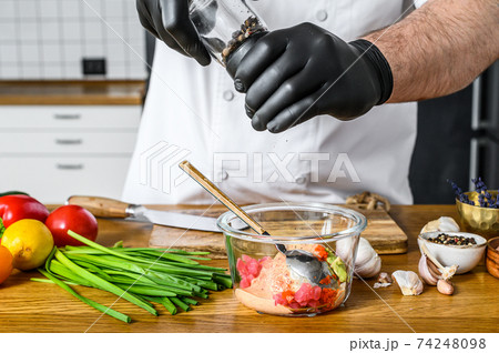 The chef in black gloves prepares tartare from fresh tuna fish The chef in black gloves prepares tartare from fresh tuna fish 74248098