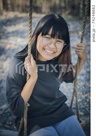face of asian teenager relaxing on rope swing face of asian teenager relaxing on rope swing 74248662