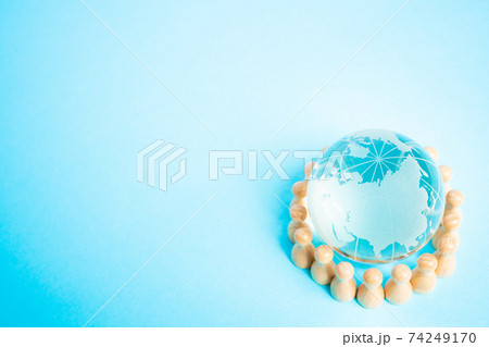 地球と手を繋ぐ人々のイメージ ガラスの地球儀とミニチュア人形 地球と手を繋ぐ人々のイメージ ガラスの地球儀とミニチュア人形 74249170