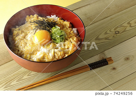 卵黄、みつば、刻み海苔の乗っている熱々玉子丼とお箸 卵黄、みつば、刻み海苔の乗っている熱々玉子丼とお箸 74249256