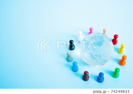 地球と手を繋ぐ人々のイメージ　ガラスの地球儀とミニチュア人形 74249635