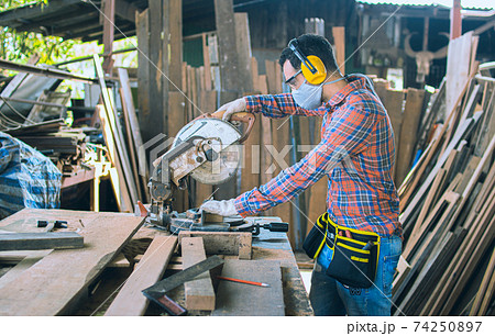 A carpenter is working in a woodworking office.caucasion white male carpenter using electric circular saw cut wood A carpenter is working in a woodworking office.caucasion white male carpenter using electric circular saw cut wood 74250897