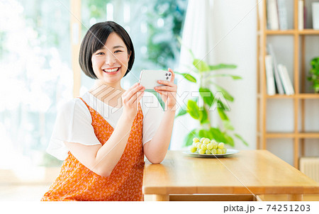 スマホで動画を見る若い女性 スマホで動画を見る若い女性 74251203