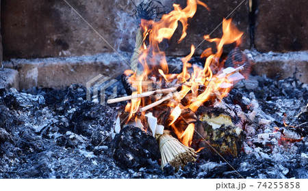 お焚き上げの炎　古い正月飾りや縁起物がお清めの炎で炭と灰になる 74255858