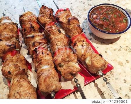 shish kebab on skewers on a plate and salsa sauce. shish kebab on skewers on a plate and salsa sauce. 74256001