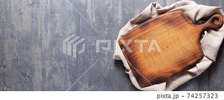 Bread cutting board and cloth napkin on stone surface of table. Food recipe concept 74257323