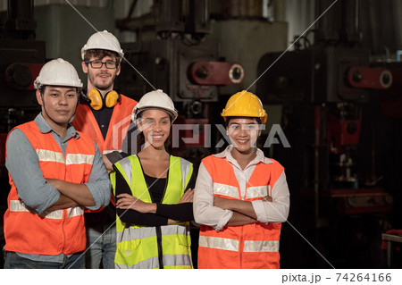Group of Team Worker mix race  enjoy working in heavy factory standing together happy smiling 74264166