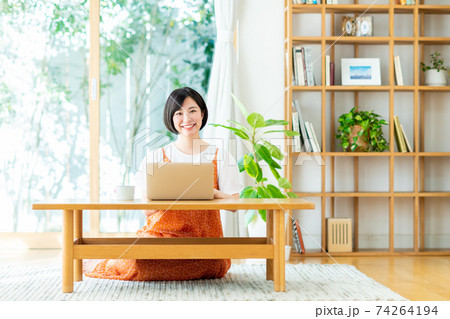 リビングでパソコンを使う若い女性 74264194