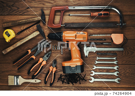 Cordless screwdriver and tool kit on an old wooden table 74264904