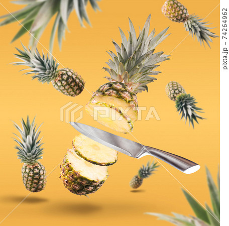 Fresh ripe pineapple with leaves falling in the air. pineapple isolated on yellow background. fresh fruit levitation concept. Fresh ripe pineapple with leaves falling in the air. pineapple isolated on yellow background. fresh fruit levitation concept. 74264962