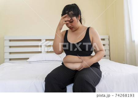 Overweight woman wear sport bar pinches fat on her belly large size Overweight woman wear sport bar pinches fat on her belly large size 74268193