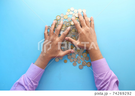 top view of man hand counting coins on color background top view of man hand counting coins on color background 74269292