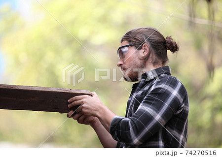 Carpenter, he is working in the workshop. Man at work on wood. Image of mature carpenter in the workshop, furniture making concept. 74270516
