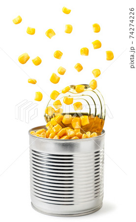 Canned corn flies out of a metal can on a white Canned corn flies out of a metal can on a white 74274226