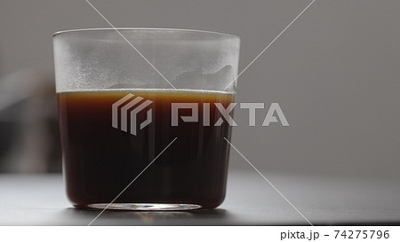 pour water in coffee in tumbler glass on concrete countertop with copy space 74275796