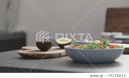 make salad with kale, mozzarella, avocado and cherry tomatoes, remove seed from avocado make salad with kale, mozzarella, avocado and cherry tomatoes, remove seed from avocado 74276013