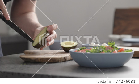 man make salad with kale, mozzarella, avocado and cherry tomatoes, cut avocado man make salad with kale, mozzarella, avocado and cherry tomatoes, cut avocado 74276031