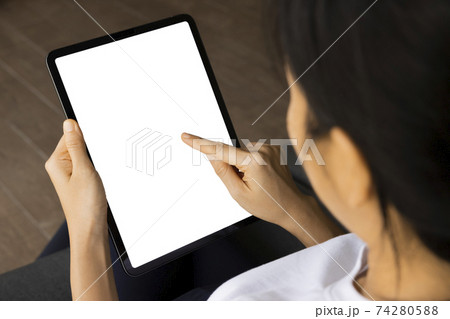Close-up woman of hand held with digital tablet white screen on sofa in the living room. Concept of technology, connection, communication Close-up woman of hand held with digital tablet white screen on sofa in the living room. Concept of technology, connection, communication 74280588