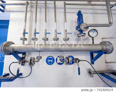 Natural gas pipes with ball valves and fittings on the wall. 74280624