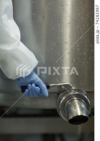 Worker Opening Barrel Tap at Factory Worker Opening Barrel Tap at Factory 74282967