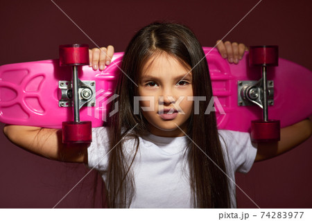 little child girl holding pink skateboard 74283977