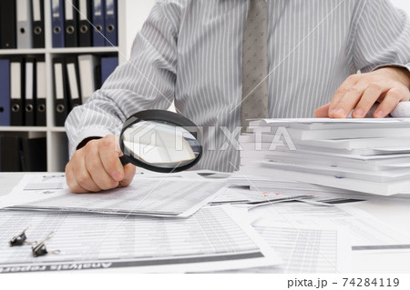 business concept - businessman's working table close view, checks financial reports, writes and counts business concept - businessman's working table close view, checks financial reports, writes and counts 74284119