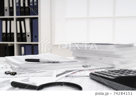 business concept - businessman's working table close view, checks financial reports, writes and counts business concept - businessman's working table close view, checks financial reports, writes and counts 74284151