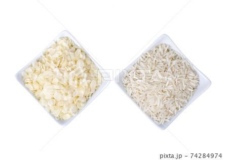 Whole grains of rice and flattened rice flakes in bowls, isolated on white Whole grains of rice and flattened rice flakes in bowls, isolated on white 74284974